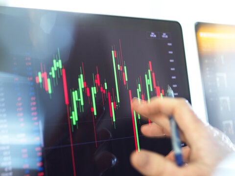 Close-up of broker hand and computer monitor with graph