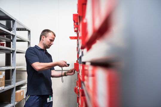 Man in storehouse of a factory scanning goods