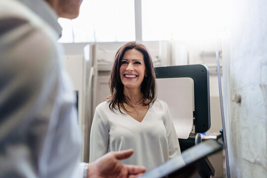 Businesswoman and businessman discussing plan on board in a factory
