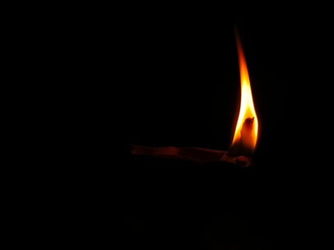 Happy Diwali. Clay diya candle illuminated in Dipavali, Hindu festival of lights. Traditional oil lamp on dark background, copy space.