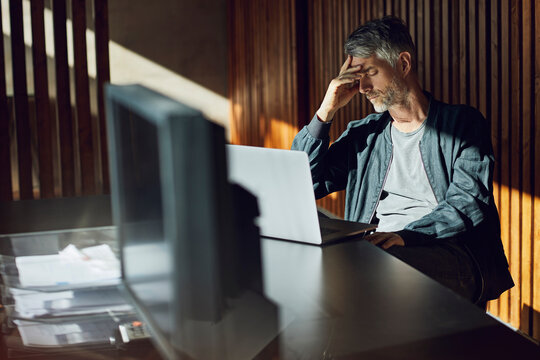 Casual businessman sitting in his sustainable office, had in hand