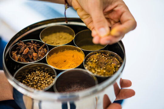 Woman holding tin box with choice of spices
