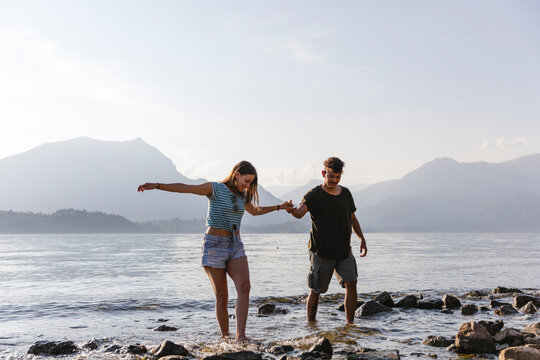 Young couple walking hand in hand at the lakeside