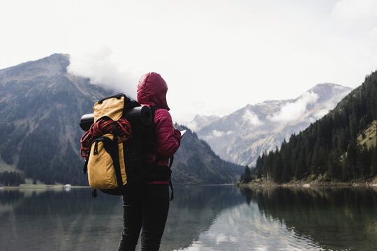 Austria, Tyrol, Alps, hiker standing at mountain lake