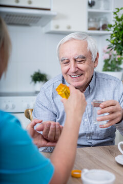 Gereatric nurse giving tablets to patient