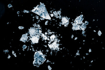 Pieces of crushed ice cubes on a black background. Ice debris pattern.