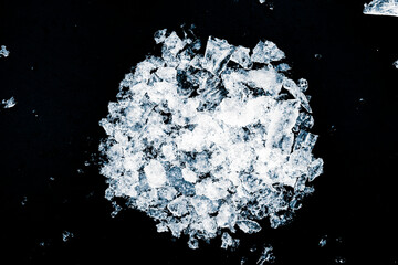 A heap of crushed ice on a black background. View from above.