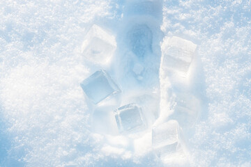 Imprint from the bottle on the fluffy, snowy surface with sunlight surrounded by ice cubes.
