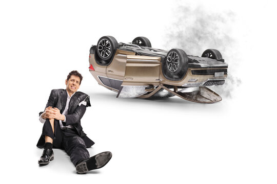 Injured man on ground after car rollover accident