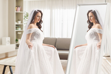 Naklejka premium Bride trying a wedding dress in front of a mirror
