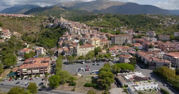 Aerial view of a historic town nestled against a lush hillside. Panorama of Scalea, a town in the province of Cosenza, in Calabria, Southern Italy. The Calabrian Apennines are in the background.