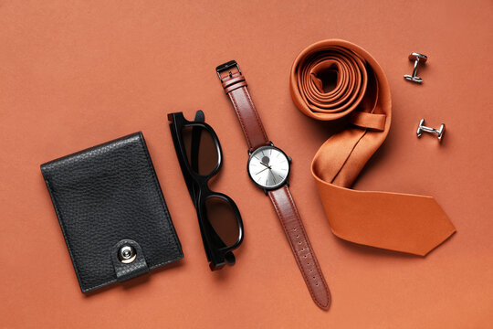 Composition with stylish male tie, sunglasses, watches and wallet on brown background