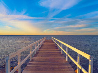 Fototapeta premium wooden bridge over the sea at sunset time