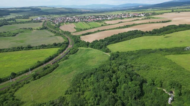 Aerial view of Train ride on rails in eastern Slovakia countryside, summer landscape, 4K