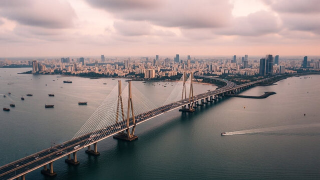 Aerial view of Bandra-Worli Sea Link bridge at sunset with Mumbai city skyline and Arabian Sea in the background.