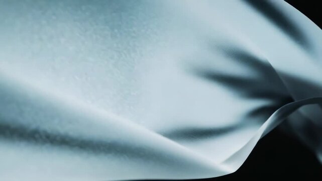 Smooth translucent fabric moving gracefully, forming elegant abstract waves and soft textures, creating a calming visual against a dark background, conveying a sense of lightness and fluidity