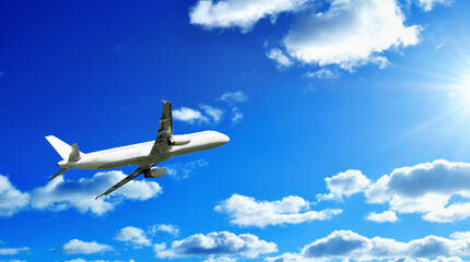 Obraz premium White commercial airplane in the sky, free space for text, air travel background with flying airplane