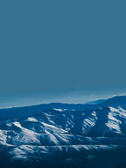 Fototapeta premium Snow Covered Mountain Range Above Horizon