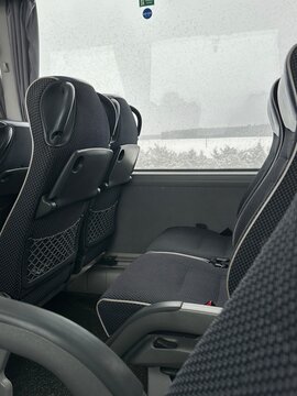 Train interior with empty passenger seats and rainy window, winter travel concept with snowy landscape outside, public transport, commute and journey background.
