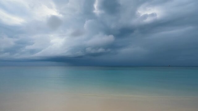 Natural tropical shoreline under gentle cloud build-up before rain. Calm yet dramatic coastal atmosphere in cinematic 4K.