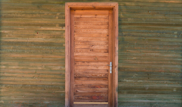 The entrance door of the wooden cabin. A modern miniature wooden house.
