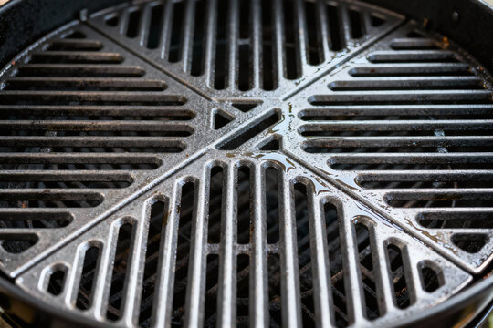 Grill and Grate Detail: a close-up photograph showcasing the intricate texture and design of a barbeque grill grate, emphasizing the geometric pattern of parallel bars.