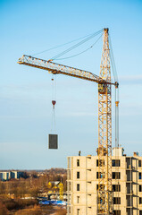 Crane on the construction site, a tower crane moving a panel slab, building of new panel houses in process