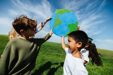 Children lifting globe to promote caring for the planet © (JLco) Julia Amaral
