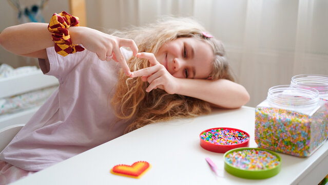 Girl making heart with hands on Valentine's Day at table