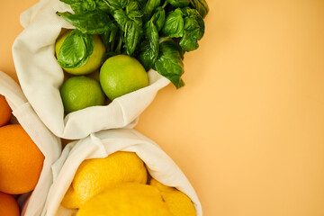 Colorful fruits and herbs are arranged in reusable cloth bags on a pastel background, highlighting the importance of eco-friendly grocery shopping and healthy eating habits.