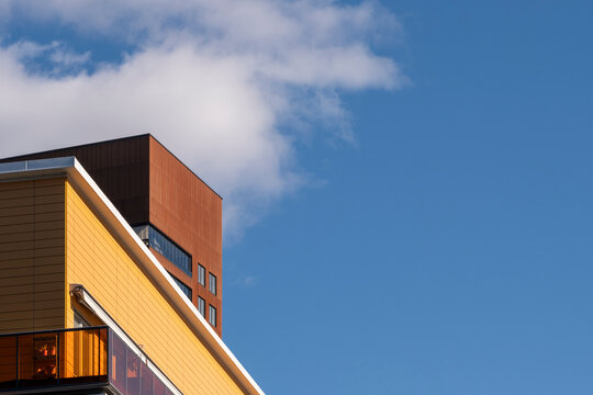Modern architecture building facade at sharp corner with strong lines framing sky and cloud creating minimal space for clean abstract background
