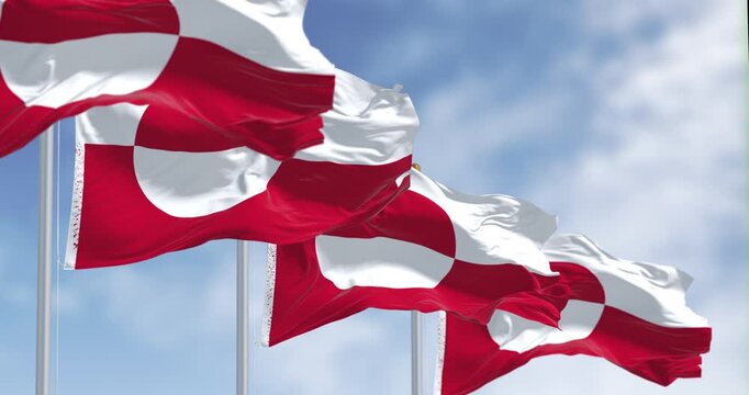 Flags of Greenland waving in the wind on a clear day.