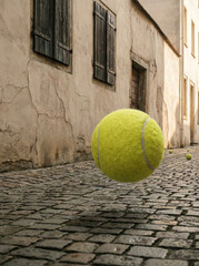 Tennis ball floating in the air in a narrow old European street