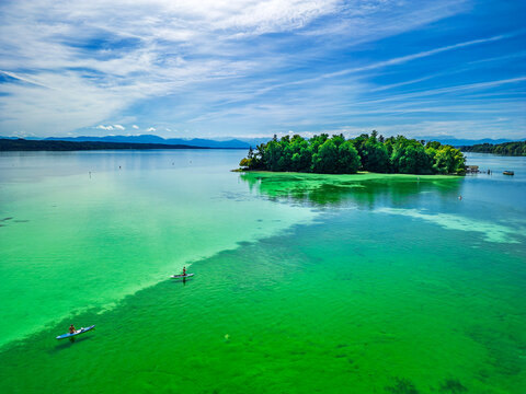 Stand-up paddler on Lake Starnberger See near Roseninsel in Bavaria