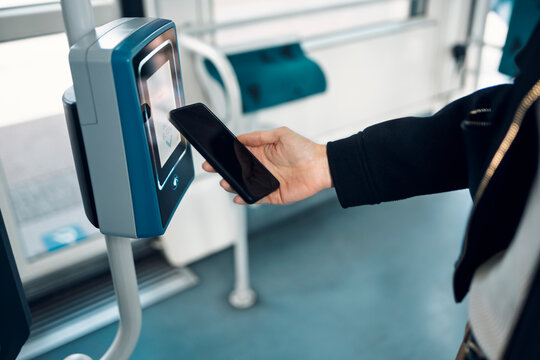 Entrepreneur using smartphone for contactless payment on public transport