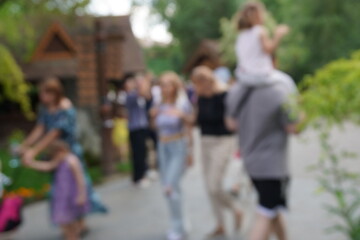 Blurred background. People are walking in the city park.