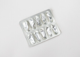 Fototapeta premium Empty foil blister pack for capsules isolated on white background. Used medications. Healthcare and medicine