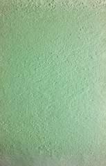 Full frame light green stucco wall texture background, rough painted cement surface for architectural design and minimalist interior backdrops.