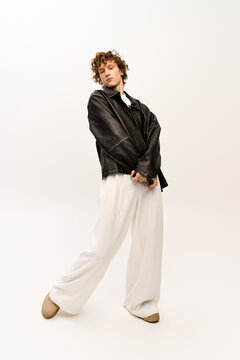 Stylish young man showcases modern fashion in a minimalist studio setting
