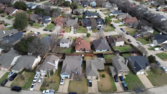 South Arlington streets near Cravens Park and Nathan Lowe Rd bend through closely spaced homes. Faded lawns, textured shingles, leafless trees, afternoon light layered residential, Arlington, TX