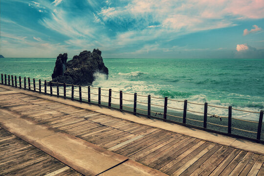 Deserted beach in stormy weather. Wooden embankment