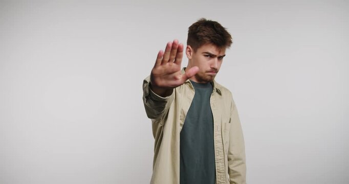 Man confidently communicates a message of pause and reflection through expressive hand gestures in a modern setting