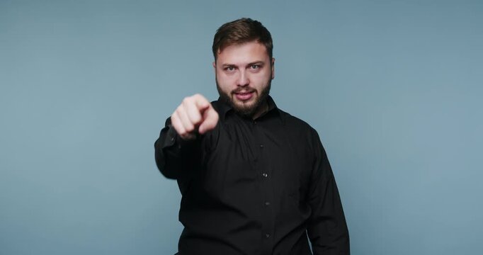 Engaging man points confidently at the audience while showcasing his charisma in a simple studio setting