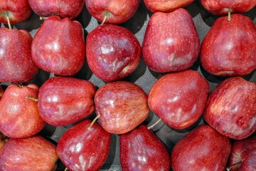 A meticulously arranged high-angle close-up showcases a collection of vibrant red apples, their skins gleaming with natural highlights, in a visually appealing and appetizing composition tha