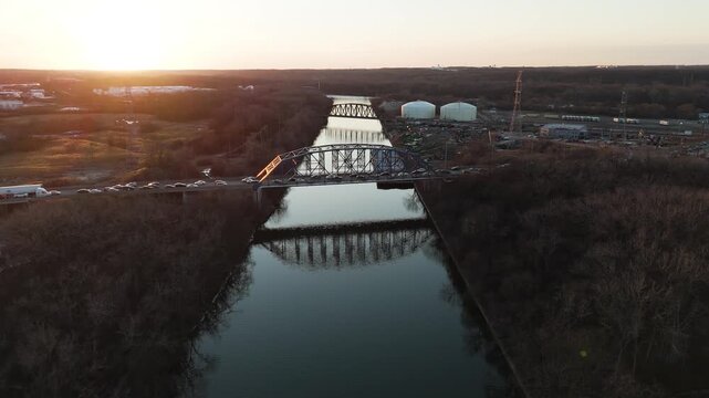 Elevated Drone Footage of Scenic River, Surrounding Nature, and Bridge at Sunset