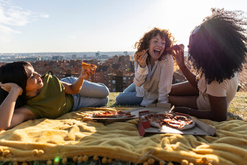 Diverse friends enjoying outdoor pizza picnic together