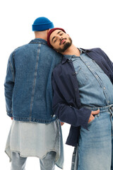 Fototapeta premium Stylish twin brothers posing creatively in trendy denim outfits with unique hats