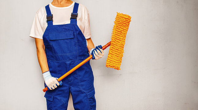 Professional cleaning service worker holding mop with copy space for advertisement.