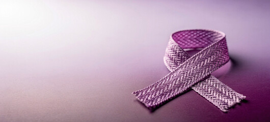 A purple ribbon lies on a purple background with a subtle gradient effect
