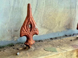Aged Rusty Metal Fence Ornaments on Weathered Concrete Wall